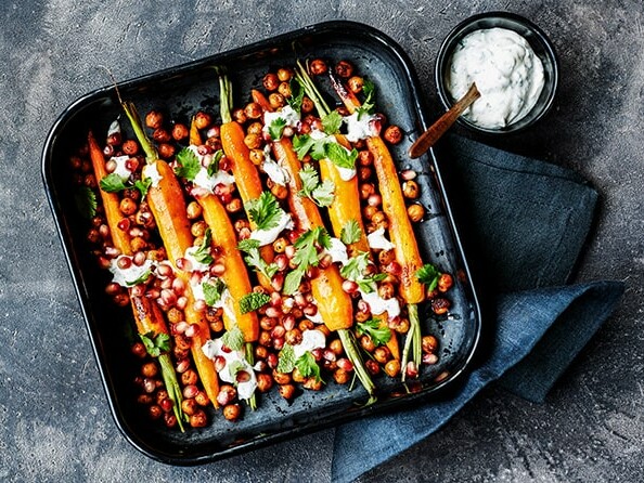 Bagte gulerødder og kikærter i fad med dressing og urter ---