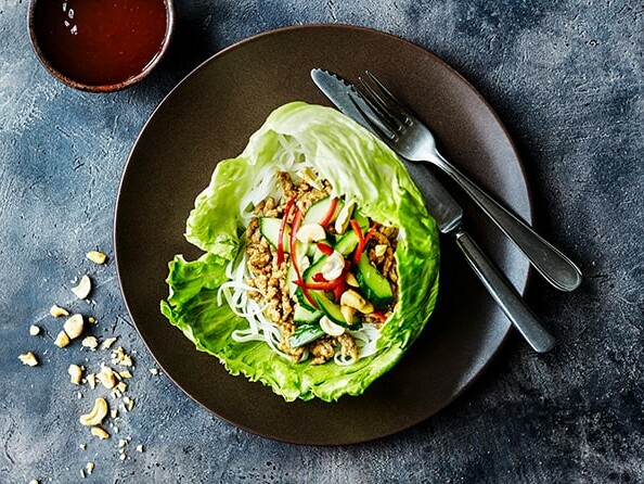 Salatwrap med nudler, grøntsager, nødder og sauce på en tallerken