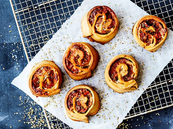 Fem gyldne tomatsnegle på en rist med bagepapir