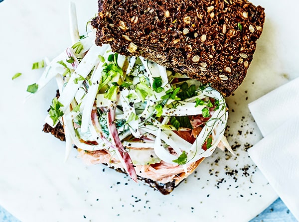 Hjemmelavet rugbrødsmad toppet med frisk salat og urter