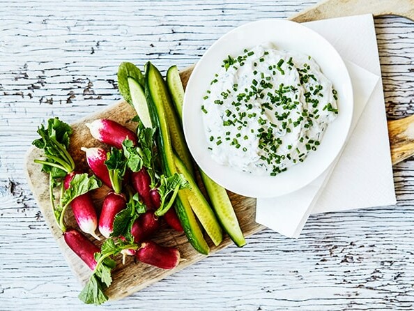 Radiser og agurk serveret med dilddip pyntet med purløg.