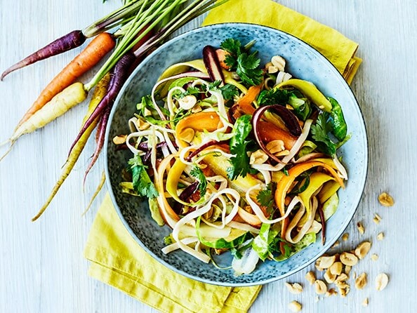 Farverig skål med nudler, gulerødder og koriander