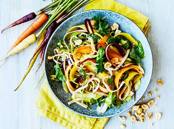 Farverig skål med nudler, gulerødder og koriander