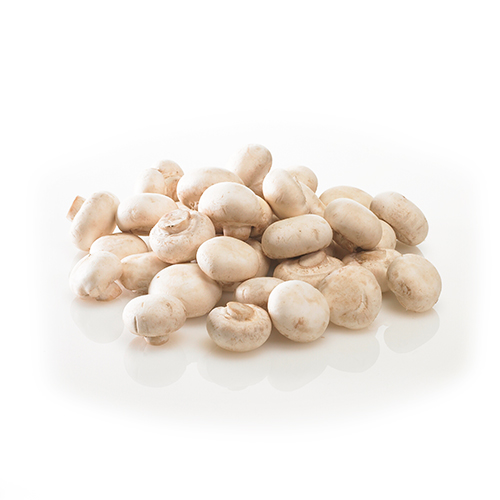 En bunke friske champignoner spredt på en hvid overflade