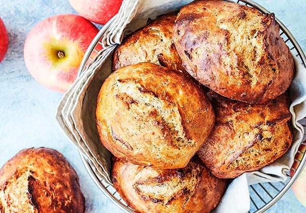 Sprøde æbleboller ved siden af friske æbler i en stofkurv