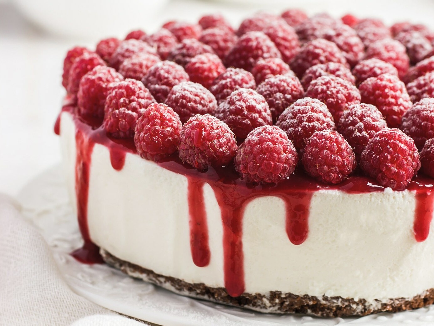 Lækker cheesecake med friske hindbær og rød glasur