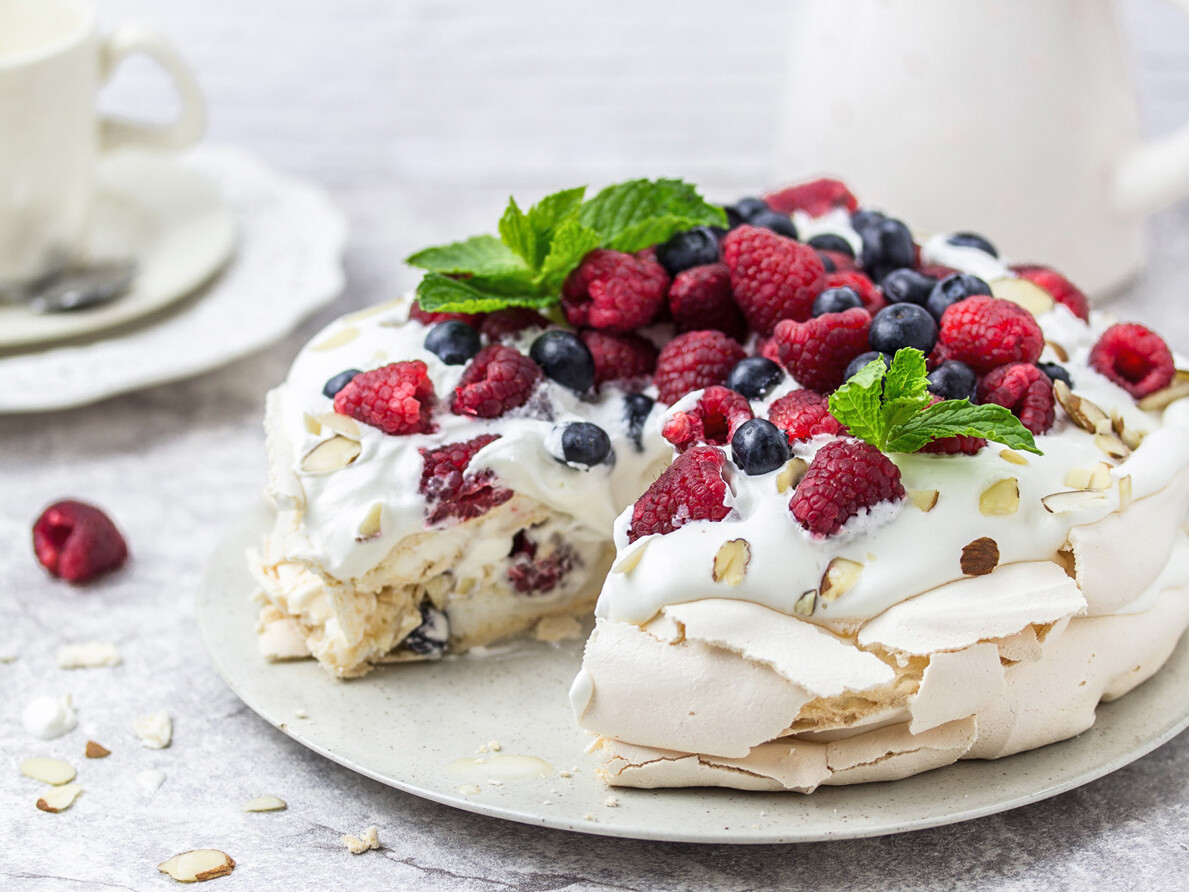 Pavlova med flødeskum toppet med friske hindbær og blåbær