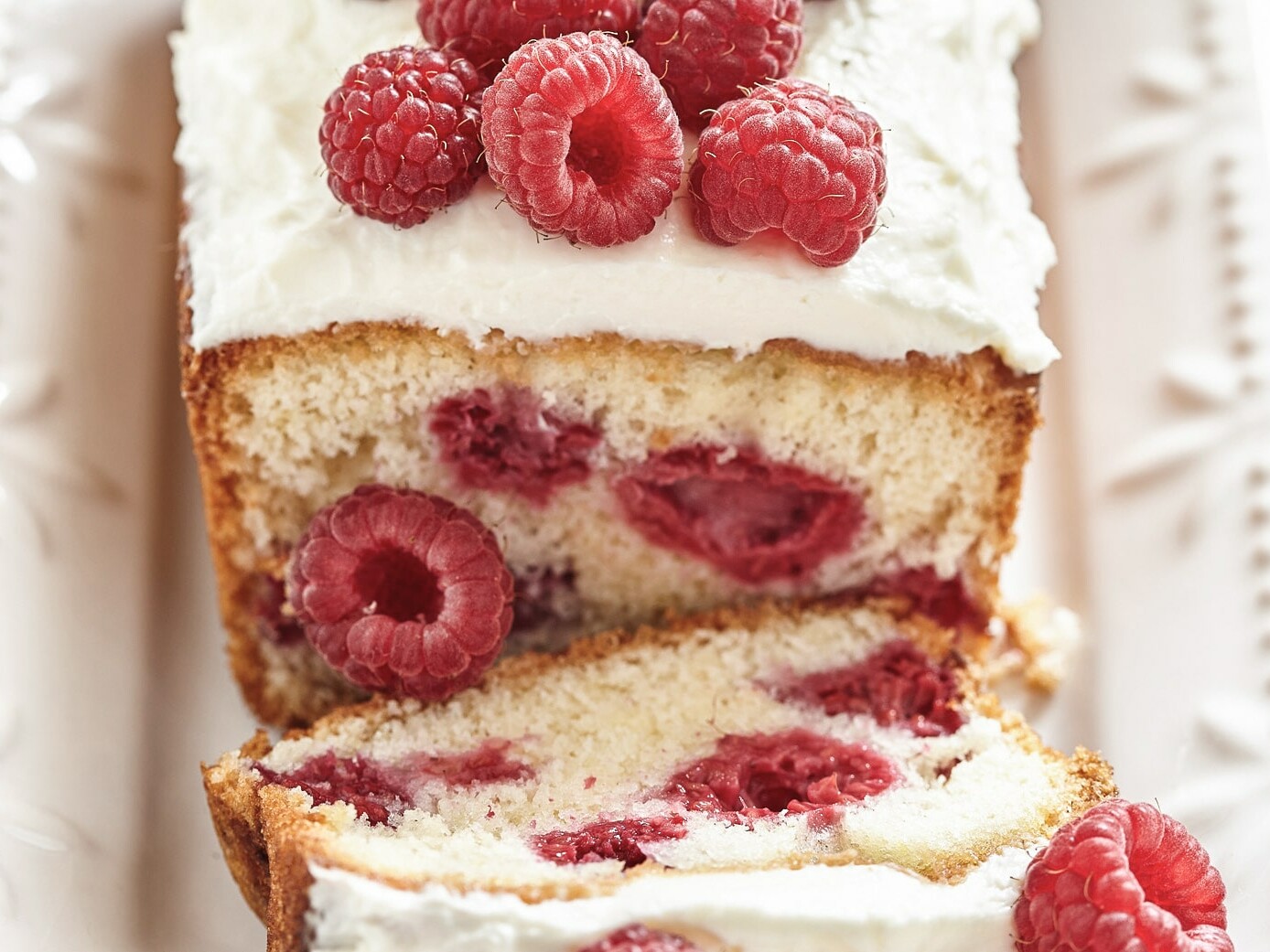 Skiver af kage med hindbær og flødeskum på toppen