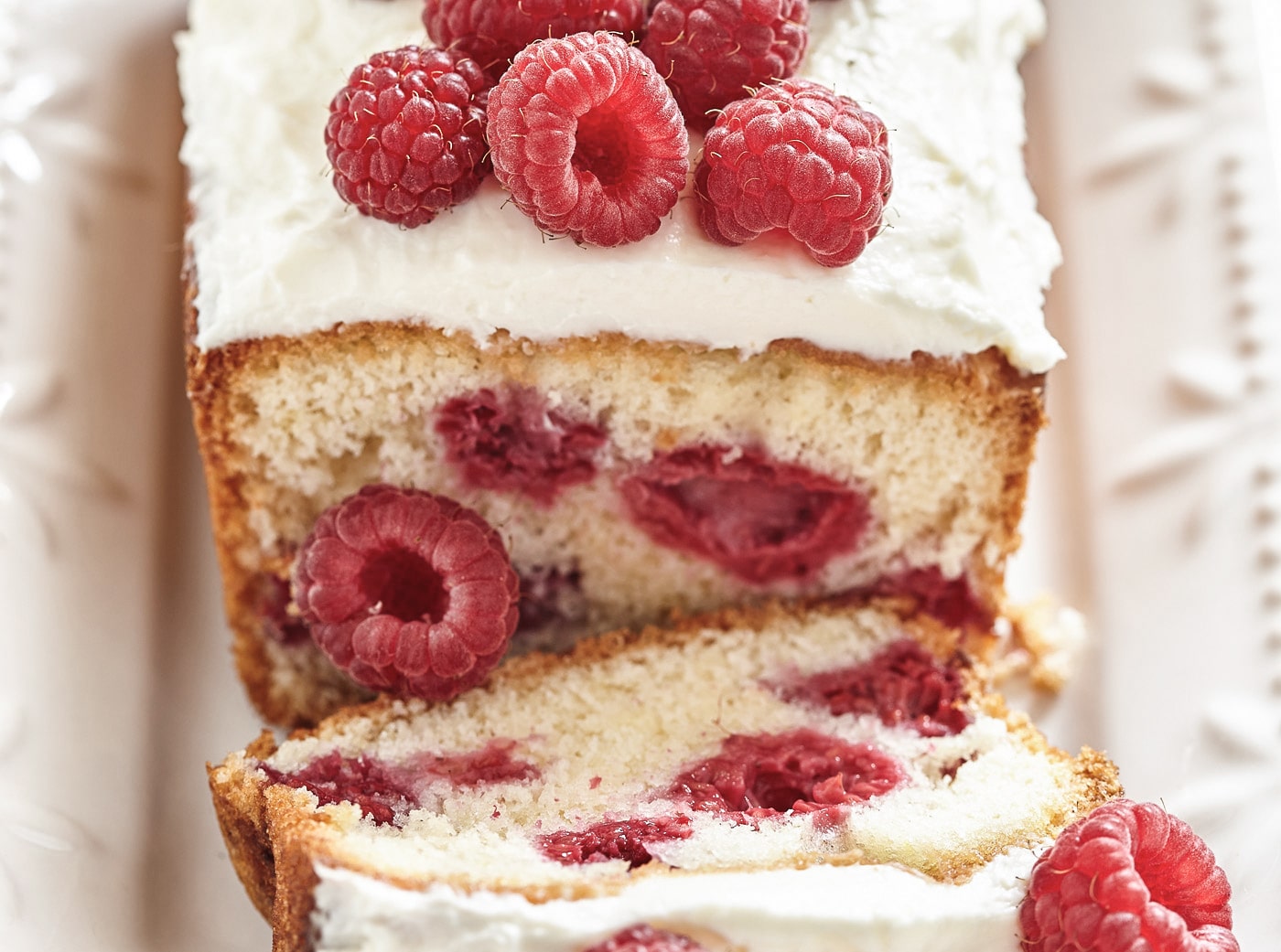 Skiver af kage med hindbær og flødeskum på toppen