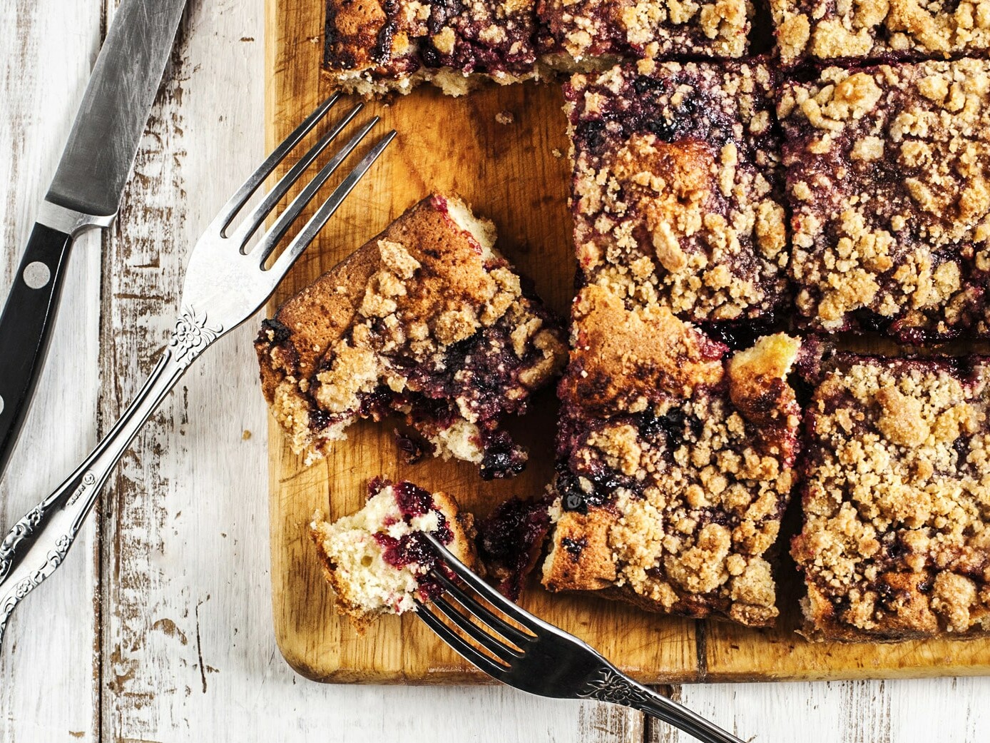 Lækker hjemmebagt smuldrekage med bær og en strø din kniv og gaffel.