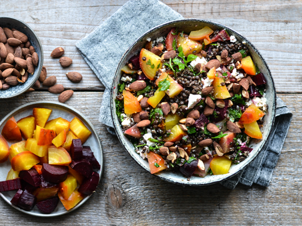 Salat med rødbeder, mandler og feta i en skål på træbord