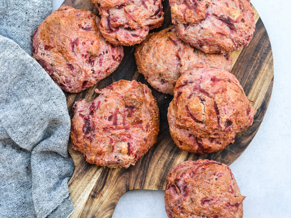 Luftige rødbedeboller arrangeret på et træskærebræt ved siden af et stofserviet.