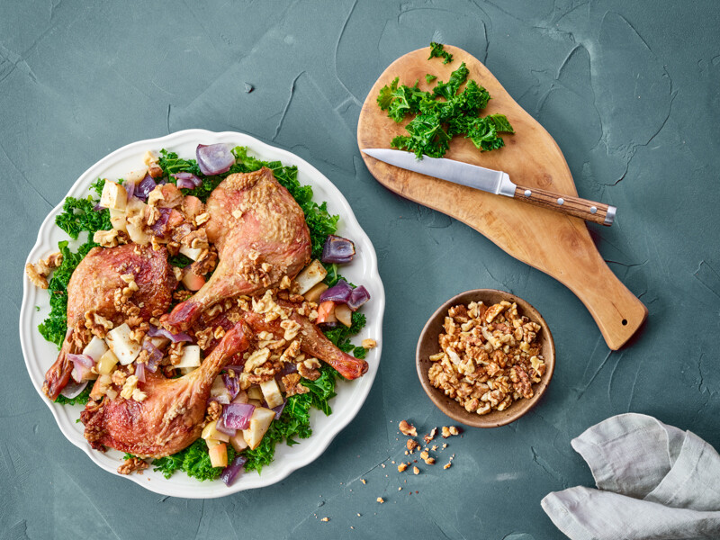 Serveret and på en tallerken med grønkål, rodfrugter og valnødder