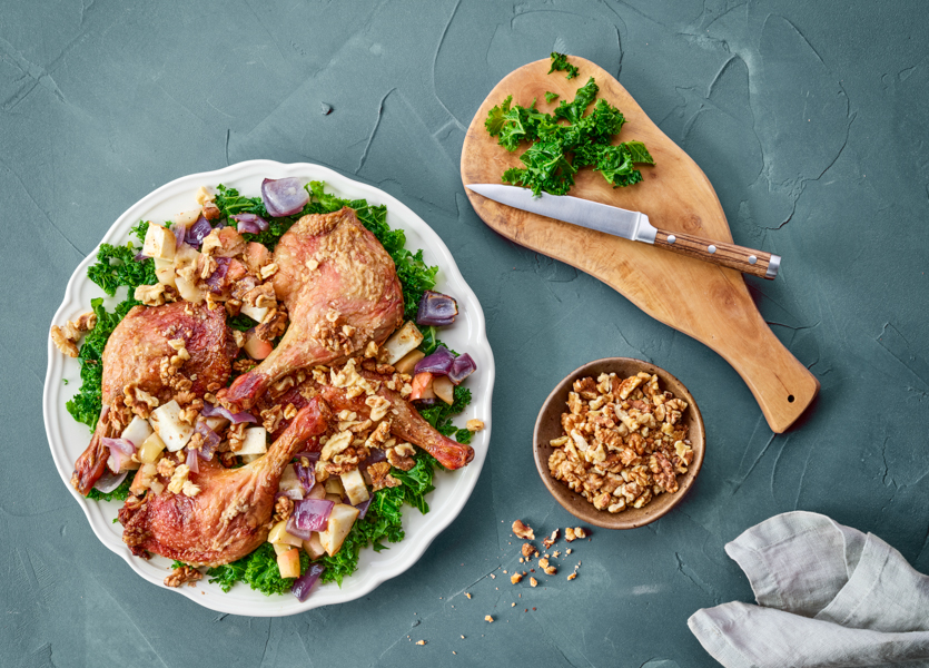 Serveret and på en tallerken med grønkål, rodfrugter og valnødder