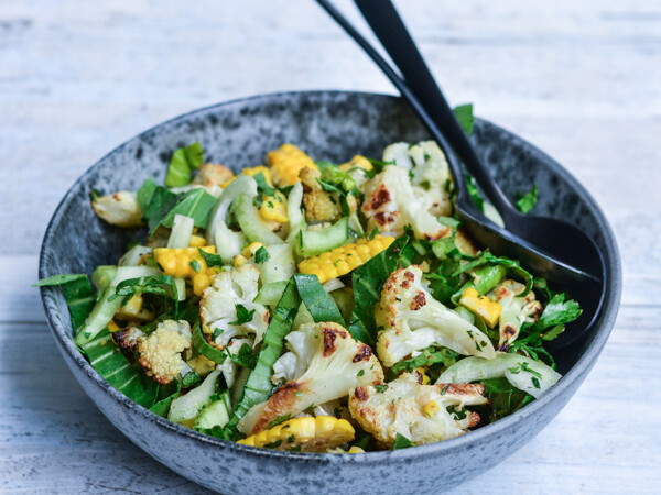 Salat med blomkål, majs og friske urter i en grå skål