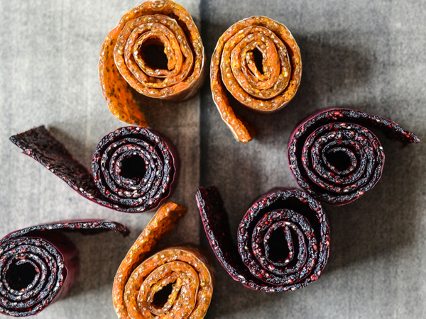 Ruller af tørret frugt i forskellige farver på grå baggrund