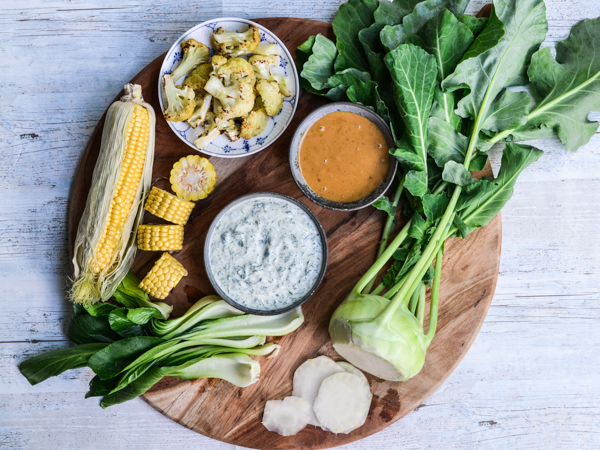 Friske grøntsager med dips på et træfad