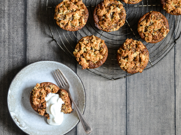Friske muffins på en bageplade med en muffin serveret på tallerken med skyr.