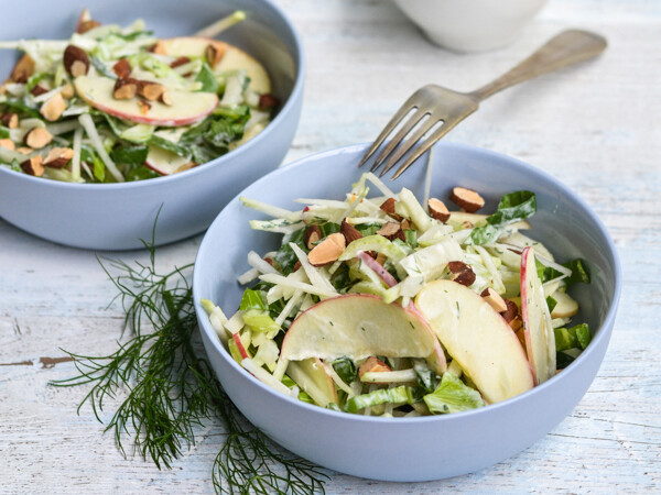 To blå skåle med æblesalat, pyntet med nødder