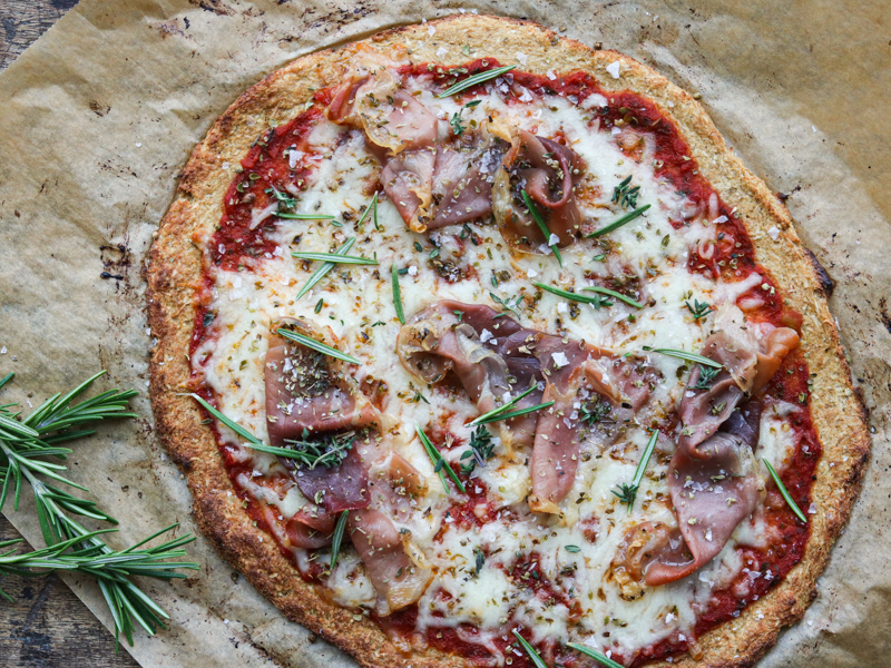 Hjemmelavet pizza med proscuitto, smeltet ost og friske rosmarinkviste
