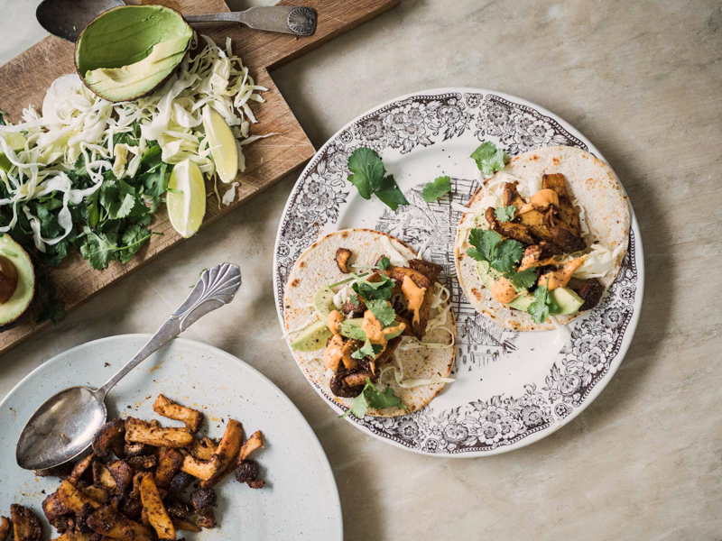 Tallerken med veganske tacos fyldt med svampe, avocado, kålsalat og koriander