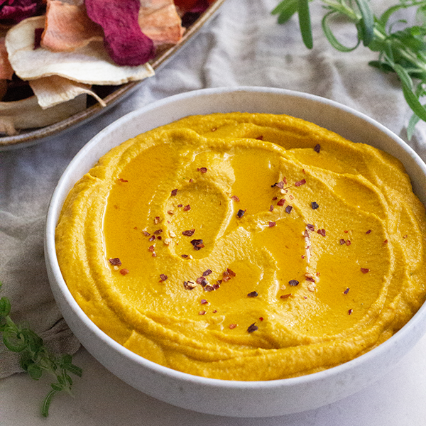 Gulerodshummus i en skål med krydderflager på toppen