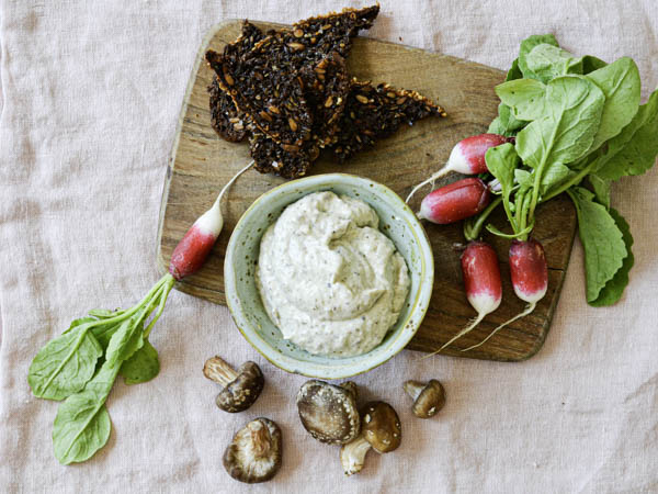 Træbræt med dip, knækbrød, radiser og svampe